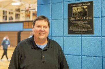 Trinity coach Tim Kelly with gym plaque