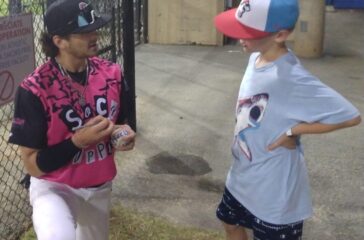 Sock Puppets Gage Miller signs while kneeling