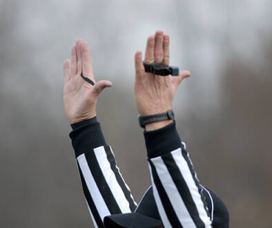 American football referee signals a touchdown.
